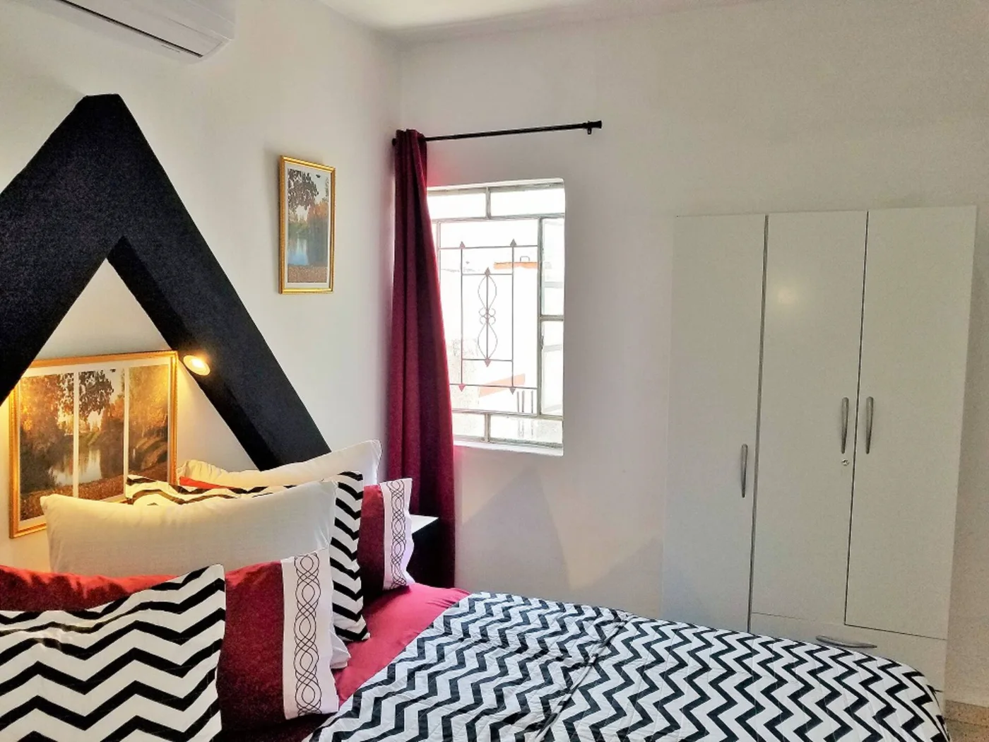Habitación con cabecero y cortinas rojas